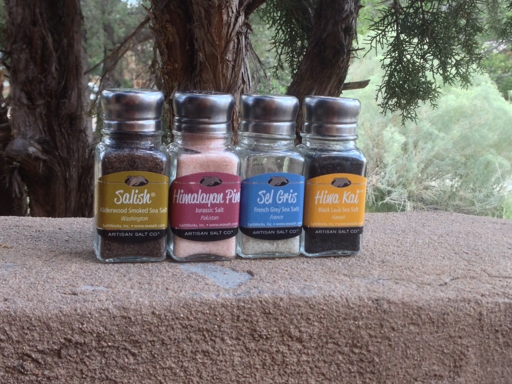 Picture of a series of salt shakers with different types of salts and their labels.